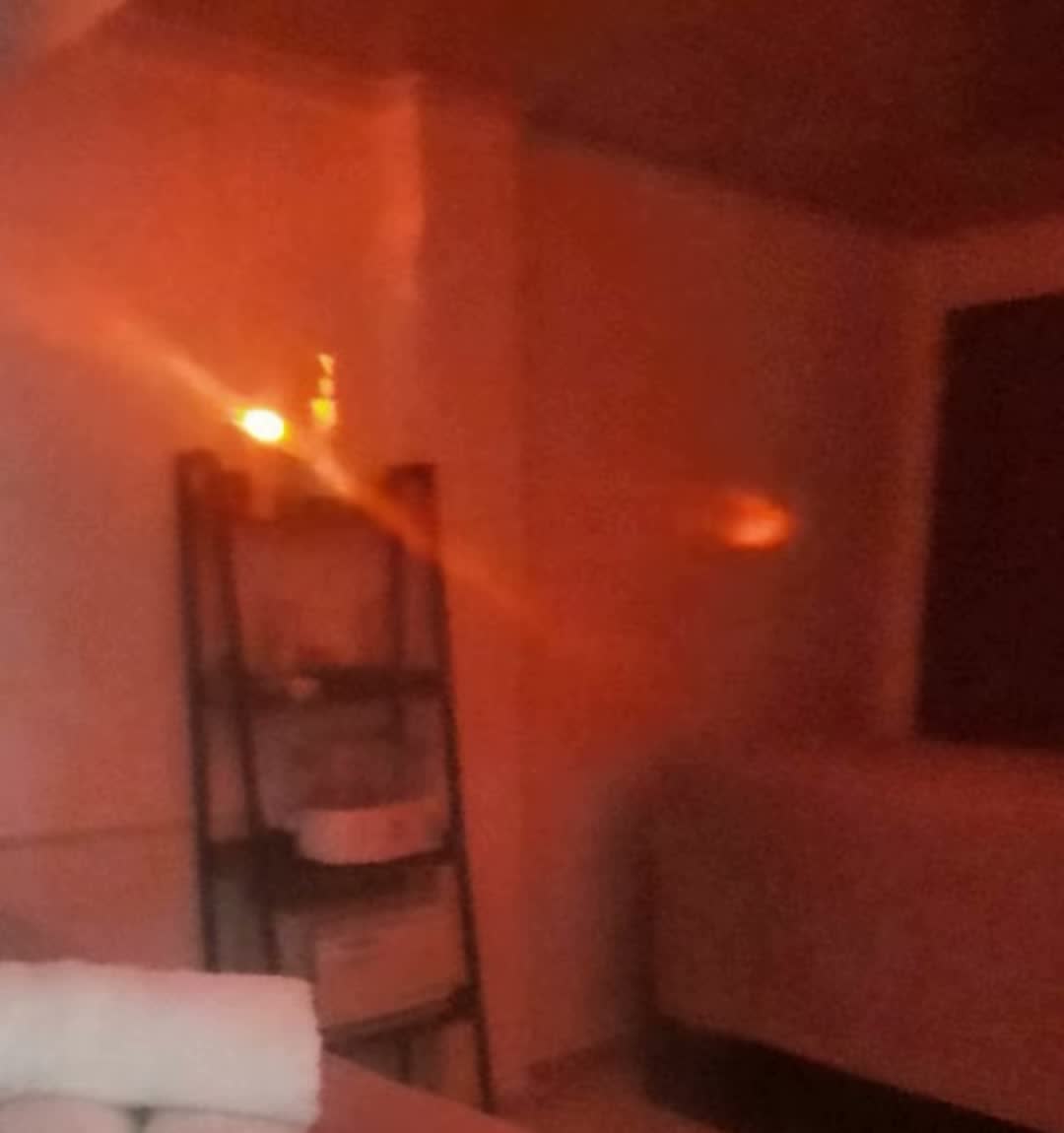 Cabina con luz cálida, toallas enrolladas y repisa
