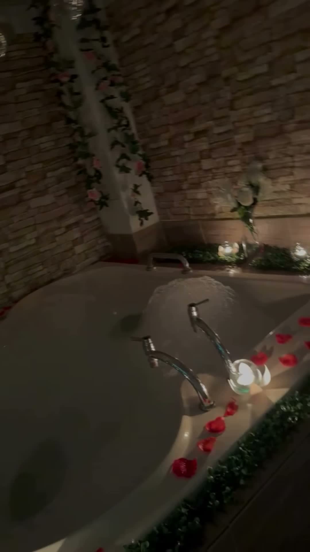 Jacuzzi en penumbra con velas y pétalos