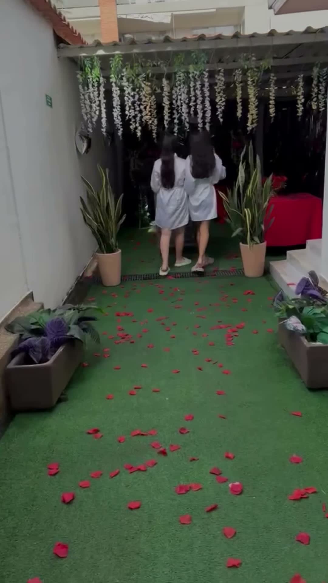 Jardín de Edilia Spa con césped, plantas, flores colgantes y pétalos de rosa