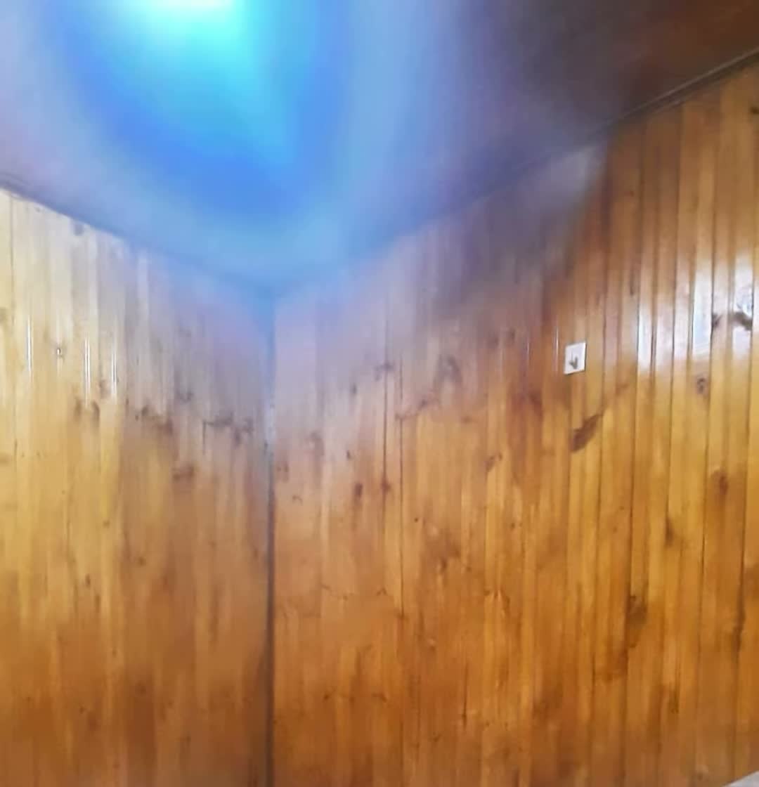 Sauna forrado en madera con toallas dobladas en forma de cisne